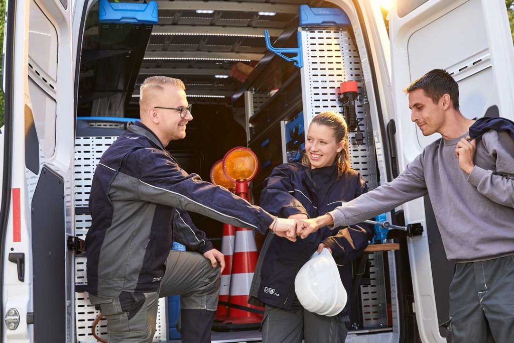 Drei Mitarbeiter von der E.DIS geben sich die Faust für Ausbildung Elektroniker für Betriebstechnik Oberhavel