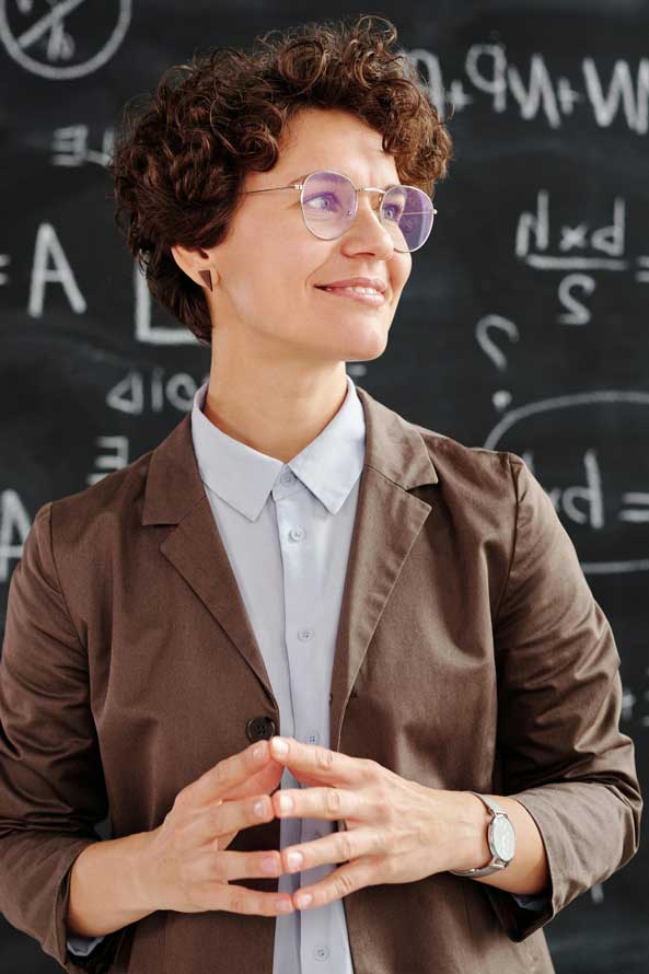 Lehrerin mit Brill vor einer Tafel mit Formeln für Berufsorientierung in Oberhavel
